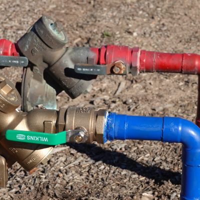 Red and blue water lines with backflow preventer